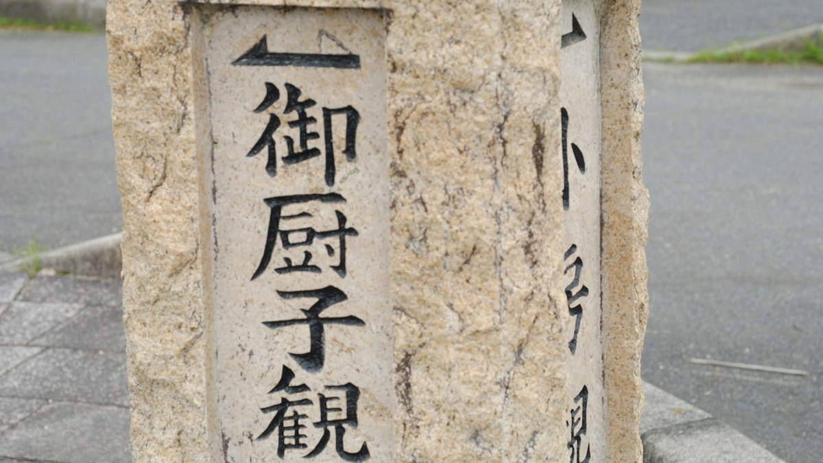 矢印と地名が刻まれた古い石の道標
