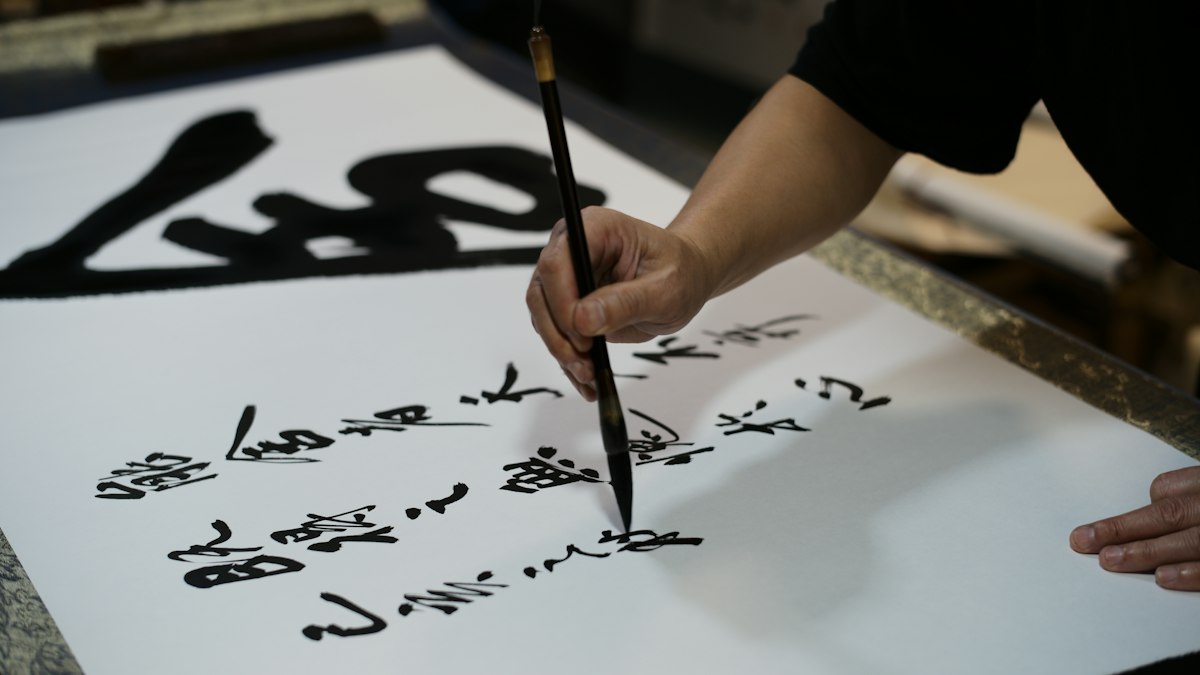 筆で漢字を書く人の手