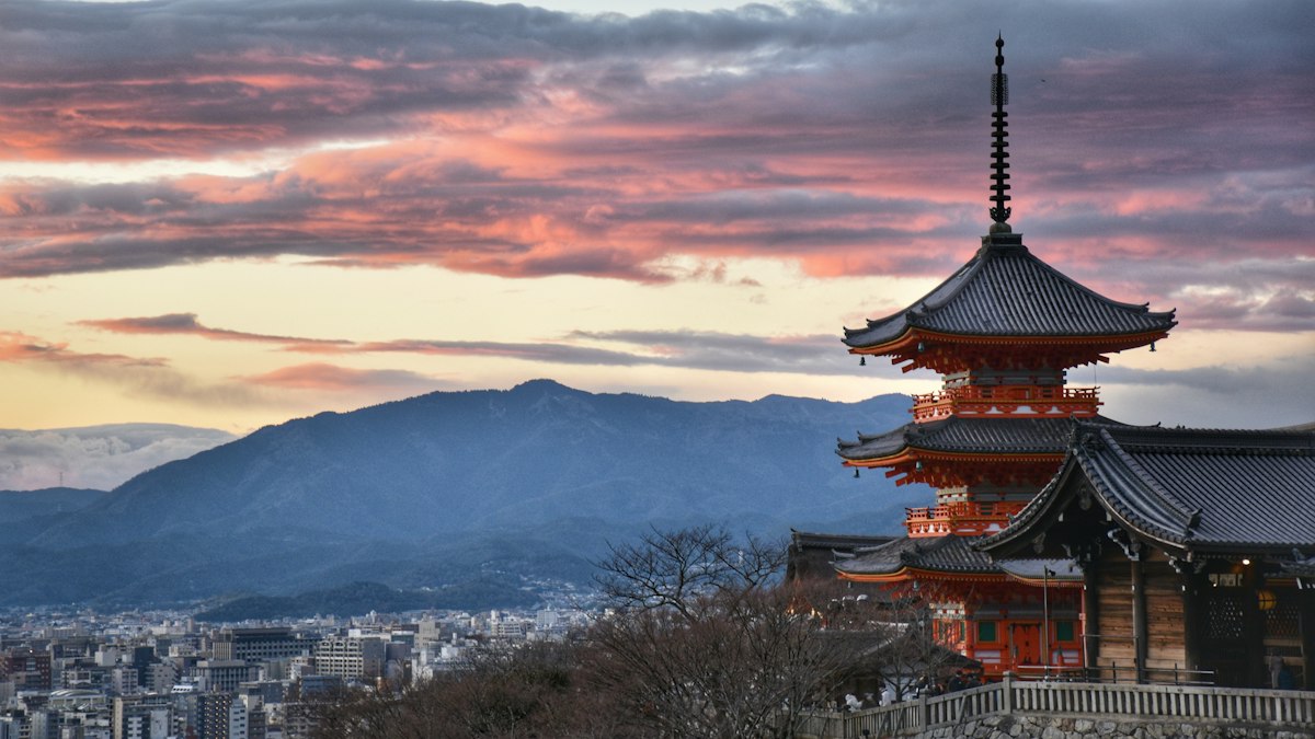 夕焼けの山並みを背にした三重塔
