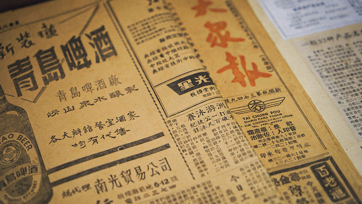 漢字の商いの広告が並ぶ古い新聞