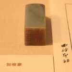 漢字が刻まれた石の印章と朱色の印影