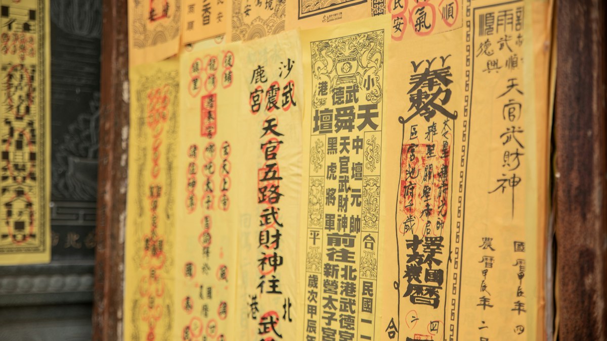 漢字が縦に並ぶ古い札が壁一面に貼られた様子