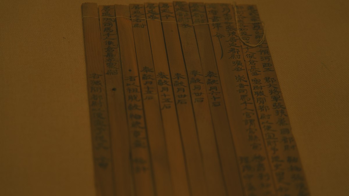 墨で漢字が書かれた古い竹簡