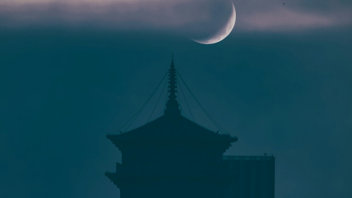 三日月の下に浮かぶ塔のシルエット