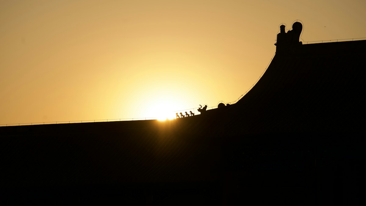 夕日に照らされた寺の屋根のシルエット