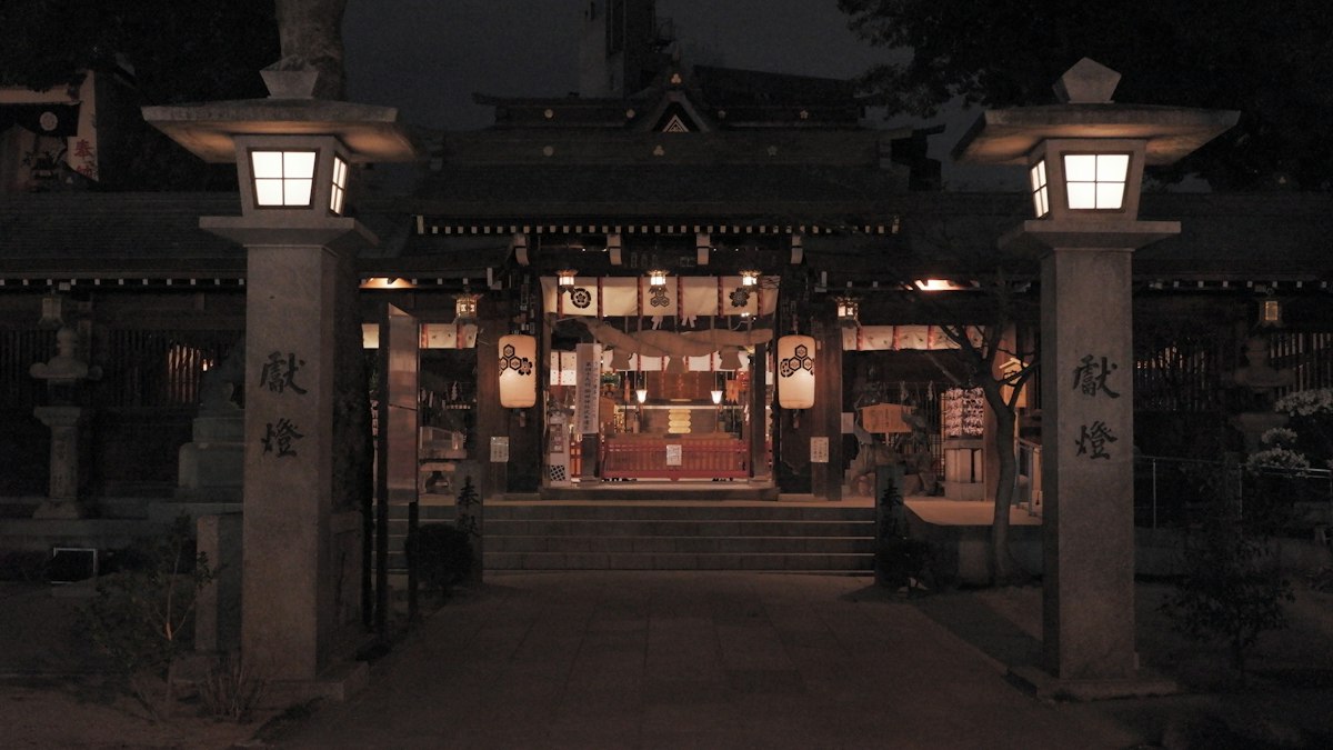石灯籠が灯る夜の神社の入口