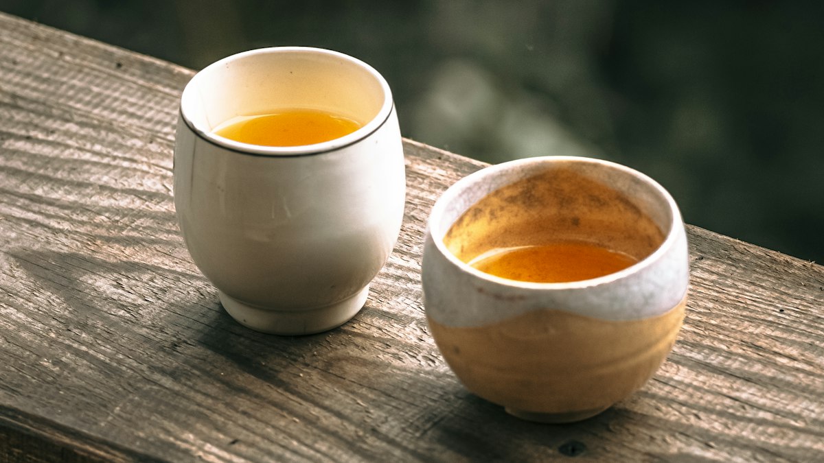 木の台に寄り添って並ぶ二つの茶碗
