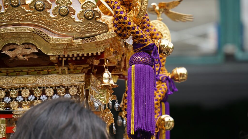 金の飾りと紫の房で彩られた神輿の屋根