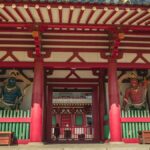 朱塗りの寺の門に立つ二体の仁王像