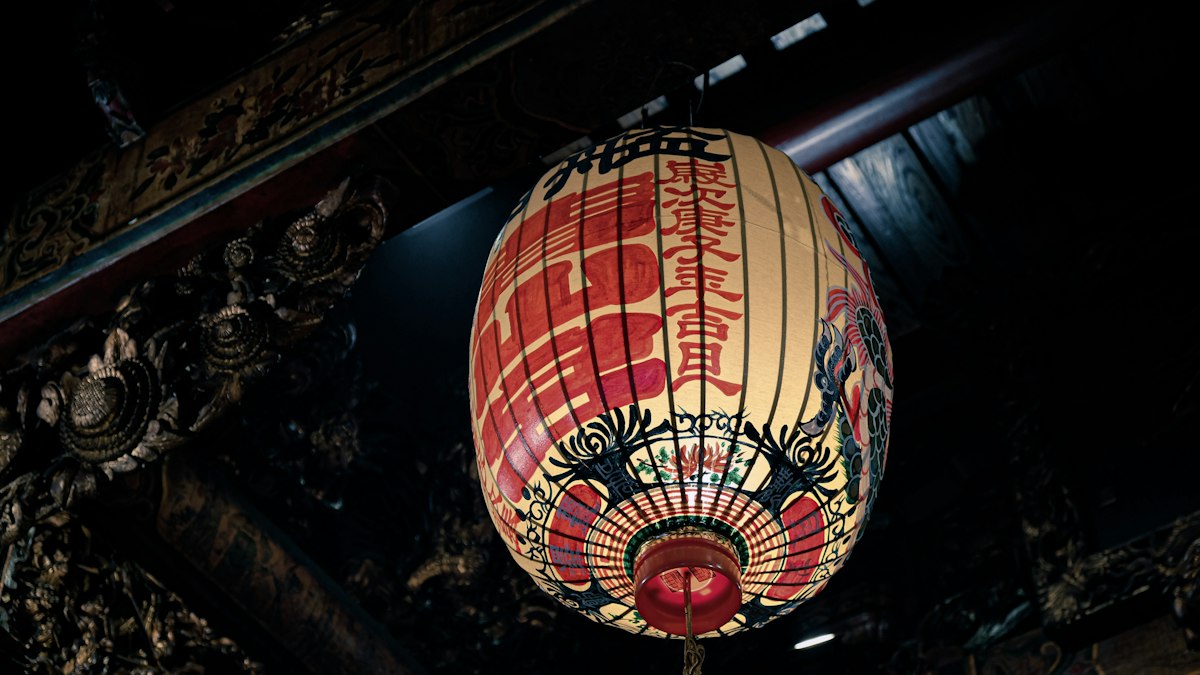 薄暗い寺の軒下に灯る赤い提灯