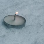雪の上で灯る小さなろうそく