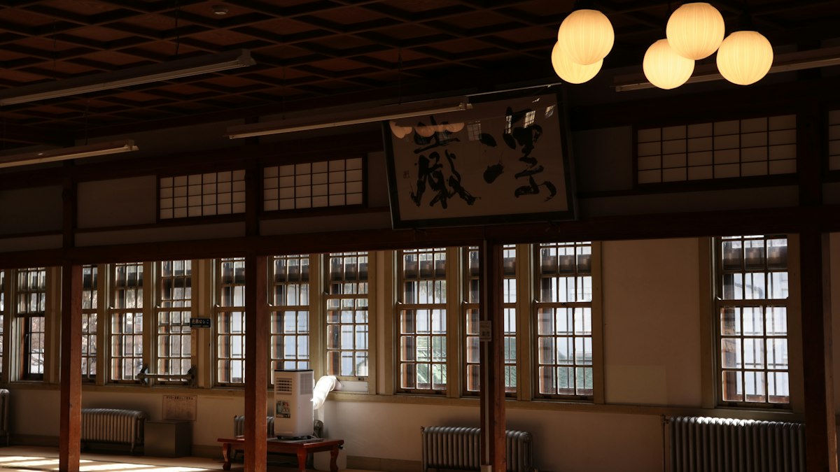 扁額の掛かる古い広間に差し込む光