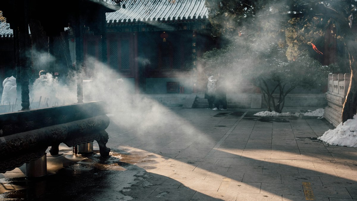 古い寺の境内に立ちのぼる香炉の煙