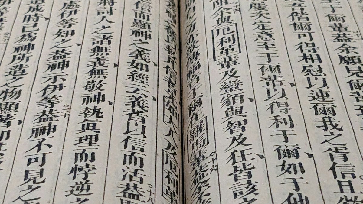 縦書きの漢字が並ぶ古い和綴じ本の見開き