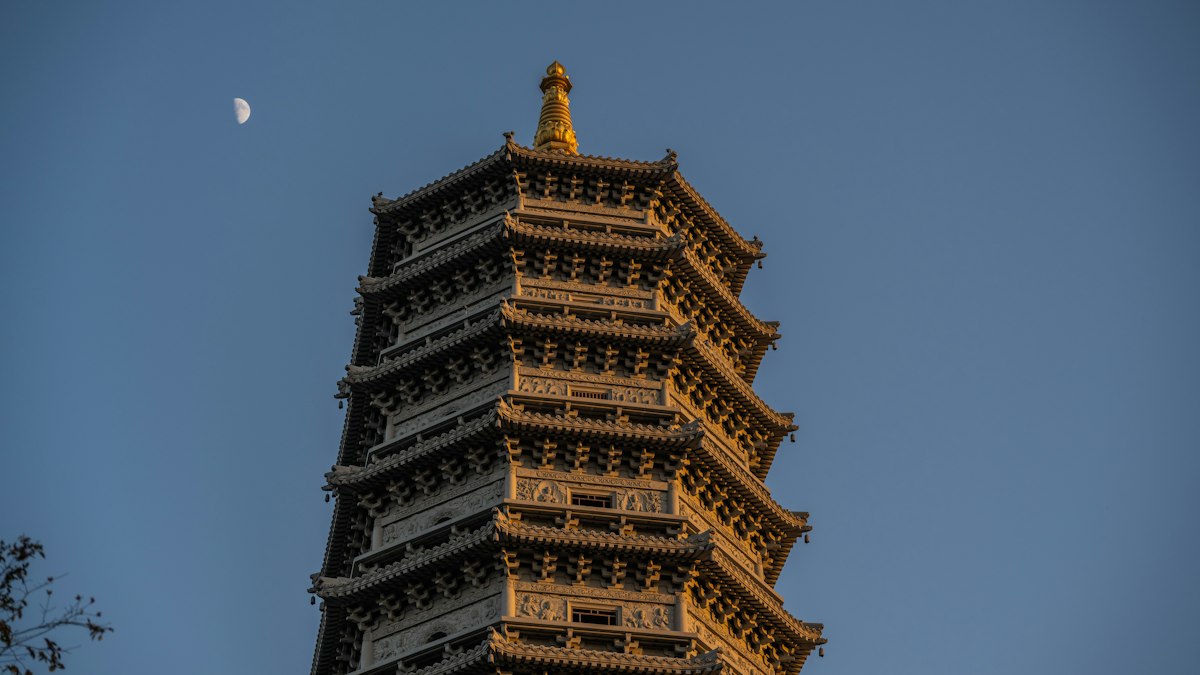 夕日に照らされる仏塔と空に浮かぶ月