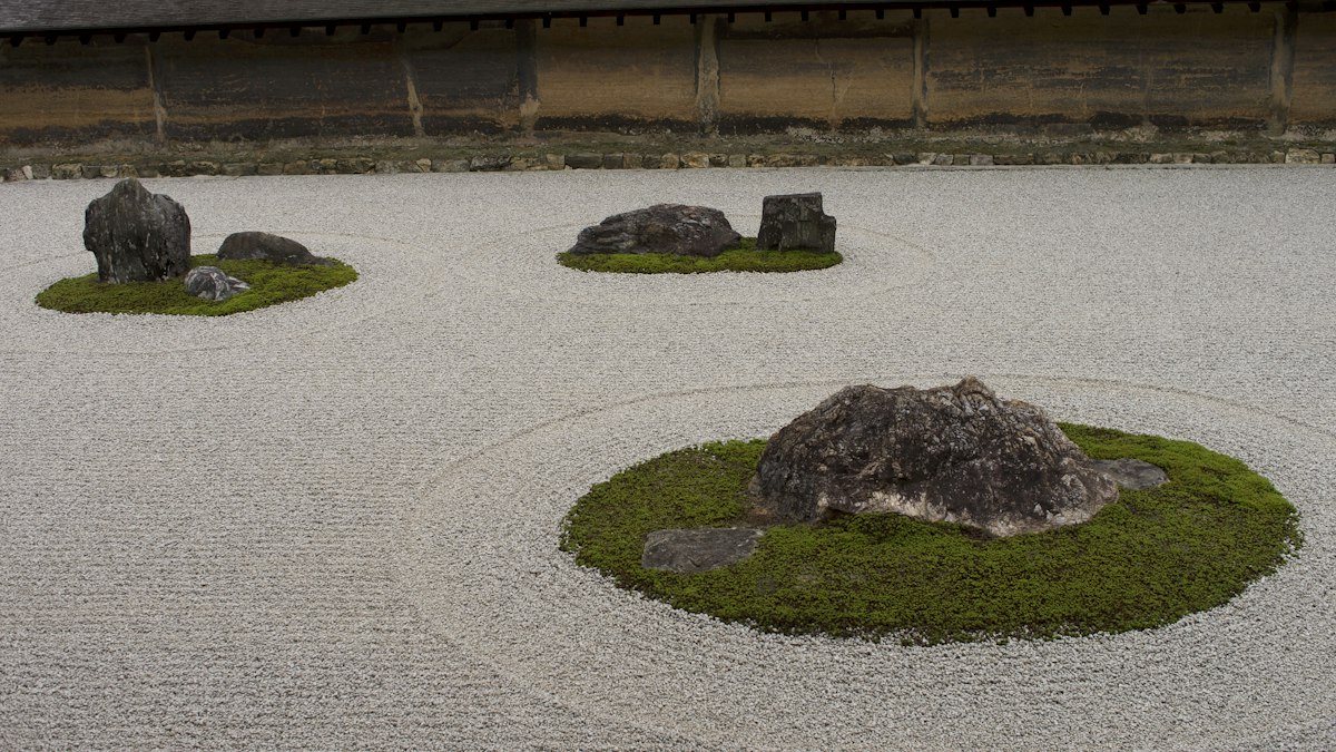 白砂に苔と石が配された枯山水の庭