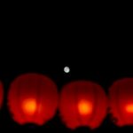 夜空の月と並んで灯る赤い提灯