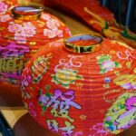花と漢字が描かれた三つの赤い提灯