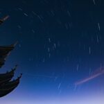 仏塔の屋根の向こうに星が円を描いて巡る夜空