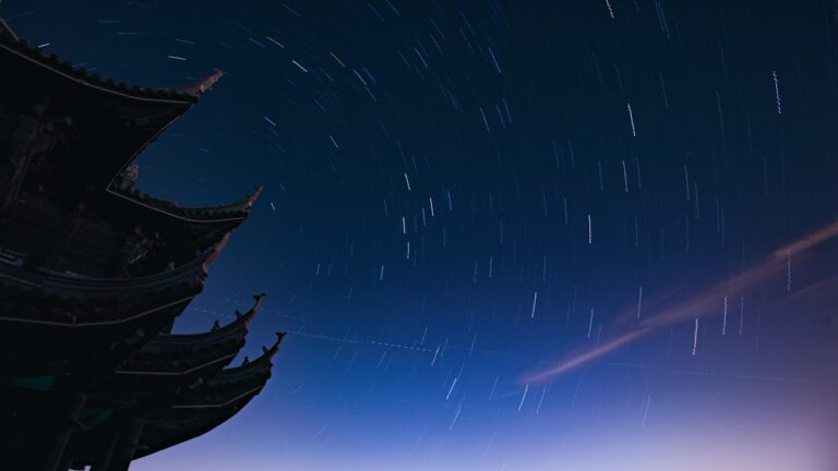 仏塔の屋根の向こうに星が円を描いて巡る夜空