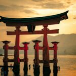 朝日に照らされて海に立つ朱色の大鳥居