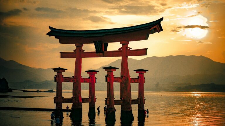 朝日に照らされて海に立つ朱色の大鳥居
