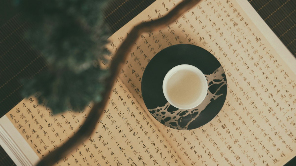 漢字の古典を開いた上に置かれた茶碗