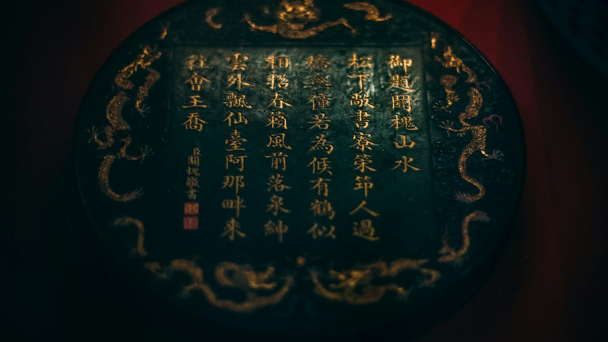 龍の文様に囲まれ金色の漢文が刻まれた黒い円盤